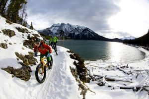 Friends mountain biking at a snowy destination