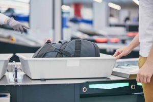 Traveler puts bag in bin at airport TSA security checkpoint