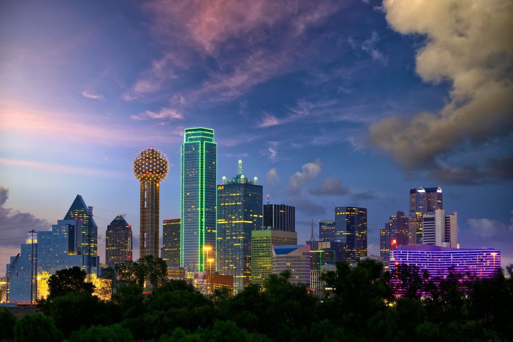 The Dallas city skyline in Texas lights up at dusk on a weekend getaway trip